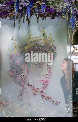 London, Großbritannien. 23 Mai 2022. Designerin Hannah Mills mit ihrer 3-D-Blumenpräsentation der Queen am Stand von Veevers Carter beim Pressetag der RHS Chelsea Flower Show auf dem Gelände des Royal Hospital Chelsea. Die Show läuft bis zum 28. Mai 2022. Kredit: Stephen Chung / Alamy Live Nachrichten Stockfoto