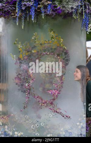 London, Großbritannien. 23 Mai 2022. Designerin Hannah Mills mit ihrer 3-D-Blumenpräsentation der Queen am Stand von Veevers Carter beim Pressetag der RHS Chelsea Flower Show auf dem Gelände des Royal Hospital Chelsea. Die Show läuft bis zum 28. Mai 2022. Kredit: Stephen Chung / Alamy Live Nachrichten Stockfoto