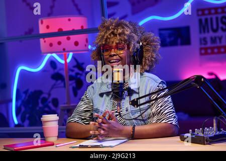 Horizontales mittleres Porträt der jungen Generation Z afroamerikanische Frau trägt modisches Outfit Aufnahme Podcast oder Inhalt für Blog Stockfoto