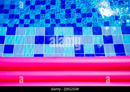 Pinke aufblasbare Matratze auf blau türkisfarbenem Wasser Swimmingpool Kopie Platz Stockfoto