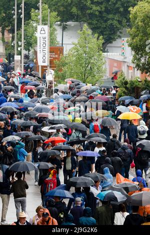 Paris, Frankreich. 23.. Mai 2022. Tennis: Grand Slam, French Open. Turnierbesucher laufen mit Regenschirmen um den Turnierplatz herum. Quelle: Frank Molter/dpa/Alamy Live News Stockfoto