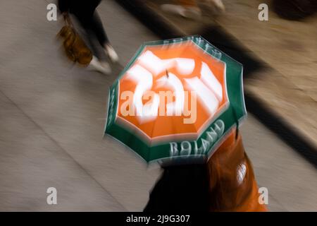 Paris, Frankreich. 23.. Mai 2022. Tennis: Grand Slam, French Open. Zwei Personen gehen mit einem Regenschirm in den Farben der French Open um den Turnierplatz. Quelle: Frank Molter/dpa/Alamy Live News Stockfoto
