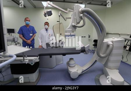 23. Mai 2022, Mecklenburg-Vorpommern, Rostock: Jan-Peter Schulz (l-r), medizinisch-technischer Radiologieassistent, und Rolf Kaiser, Chefarzt der Klinik für Innere Medizin, stehen an einer von zwei Messstationen im neuen Herzkatheterlabor im Neubau für Kardiologie, Gefäß- und Wirbelsäulenchirurgie am Klinikum Südstadt. Das 10 Millionen Euro teure Projekt, das am 23. Mai 2022 offiziell in Betrieb gehen wird, umfasst auch einen Hybrid-Operationssaal mit einer großräumigen Radiologieeinheit der neuesten Generation. Vor acht Monaten wurde der Boden gebrochen. Foto: Bernd Wüstneck/dp Stockfoto