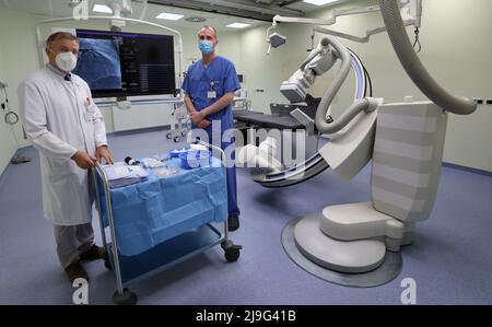 23. Mai 2022, Mecklenburg-Vorpommern, Rostock: Rolf Kaiser (l-r), Chefarzt der Klinik für Innere Medizin, und Jan-Peter Schulz, medizinisch-technischer Radiologieassistent, stehen an einer von zwei Messstationen des neuen Herzkatheterlabors im Neubau für Kardiologie, Gefäßchirurgie und Wirbelsäulenchirurgie am Klinikum Südstadt. Das 10 Millionen Euro teure Projekt, das am 23. Mai 2022 offiziell in Betrieb gehen wird, umfasst auch einen Hybrid-Operationssaal mit einer großräumigen Radiologieeinheit der neuesten Generation. Vor acht Monaten wurde der Boden gebrochen. Foto: Bernd Wüstneck/dp Stockfoto