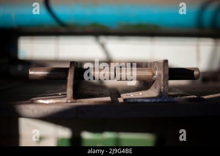Stahlteil. Dickes Metall. Gebohrte Löcher im Werkstück. Details der Metallwerkstatt. Hintergrund eines Teils der Struktur. Befestigungselemente für schwere Lasten. Stockfoto