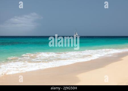 Eine Yacht, die auf dem türkisfarbenen Wasser des Atlantischen Ozeans in Santa Maria Beach, Sal, Kapverdische Inseln, Kapverdische Inseln, Afrika segelt Stockfoto