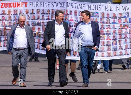 23. Mai 2022, Mecklenburg-Vorpommern, Wismar: Reinhard Meyer (M, SPD), Minister für Wirtschaft, Tourismus und Verkehr Mecklenburg-Vorpommerns, Christoph Morgen (r), Insolvenzverwalter der Werftgruppe, und Thomas Beyer (l, SPD) gehen nach einem Betriebsgespräch über das Gelände der insolventen MV Werft. Die schwedische Reedereigruppe Stena ab ist nicht mehr daran interessiert, den Bau des zur zahlungsunfähigen MV Werften-Gruppe gehörenden Kreuzfahrtschiffs „Global One“ fortzusetzen. Die Fortsetzung der Transfergesellschaft und die Rettung der 1.500 Arbeitsplätze müssen jetzt neu verhandelt werden Stockfoto