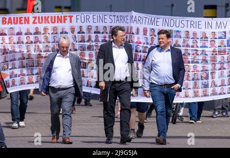 23. Mai 2022, Mecklenburg-Vorpommern, Wismar: Reinhard Meyer (M, SPD), Minister für Wirtschaft, Tourismus und Verkehr Mecklenburg-Vorpommerns, Christoph Morgen (r), Insolvenzverwalter der Werftgruppe, und Thomas Beyer (l, SPD) gehen nach einem Betriebsgespräch über das Gelände der insolventen MV Werft. Die schwedische Reedereigruppe Stena ab ist nicht mehr daran interessiert, den Bau des zur zahlungsunfähigen MV Werften-Gruppe gehörenden Kreuzfahrtschiffs „Global One“ fortzusetzen. Die Fortsetzung der Transfergesellschaft und die Rettung der 1.500 Arbeitsplätze müssen jetzt neu verhandelt werden Stockfoto