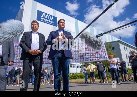 23. Mai 2022, Mecklenburg-Vorpommern, Wismar: Reinhard Meyer (l, SPD), Minister für Wirtschaft, Tourismus und Verkehr Mecklenburg-Vorpommerns, und Christoph Morgen, Insolvenzverwalter der Werftgruppe, sprechen nach einem Betriebsgespräch in der MV Werft in Wismar mit Medienvertretern vor der Schiffbauhalle. Die schwedische Reedereigruppe Stena ab ist nicht mehr daran interessiert, den Bau des Kreuzfahrtschiffs „Global One“ fortzusetzen, das zum Insolvenzbesitz der MV Werften Group gehört. Die Fortführung des Transferunternehmens und die Rettung der 1.500 Arbeitsplätze dürfen nicht Stockfoto