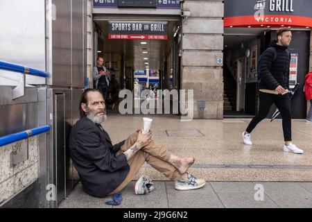 Vor der Victoria Station, London, Großbritannien, saß ein obdachloser Mann mit infiziertem Fuß und bettelte um Geld Stockfoto