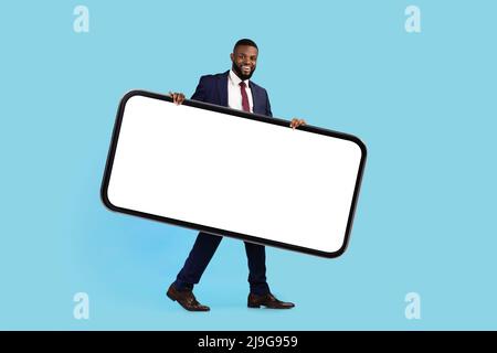 Schöner Schwarzer Geschäftsmann Im Anzug Trägt Großes Smartphone Mit Blank White Screen Stockfoto