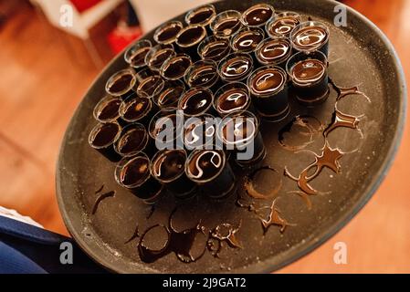 Ein Kellner trägt während einer Party ein Tablett mit vielen Gläsern Alkohol. Stockfoto