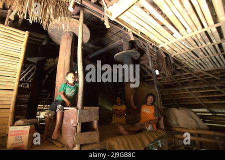 Umbu Tiu, ein Dorfbewohner, mit seiner Frau und seinem Kind in ihrem traditionellen Haus im traditionellen Dorf Praijing in Tebara, Waikabubak, West Sumba, East Nusa Tenggara, Indonesien. Stockfoto