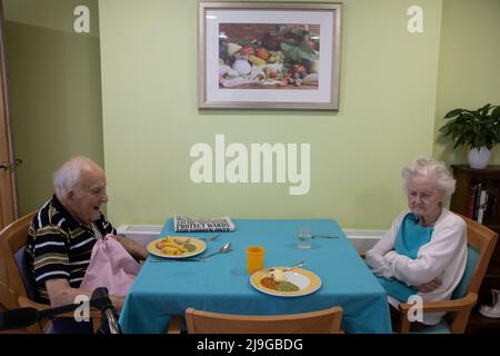 Ein älteres Paar saß an einem Esstisch in einem Pflegeheim in England, Großbritannien Stockfoto