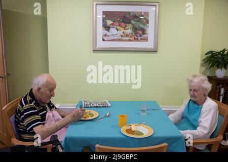 Ein älteres Paar saß an einem Esstisch in einem Pflegeheim in England, Großbritannien Stockfoto