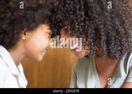 Lächelnde Mutter und Tochter sahen einander Stockfoto