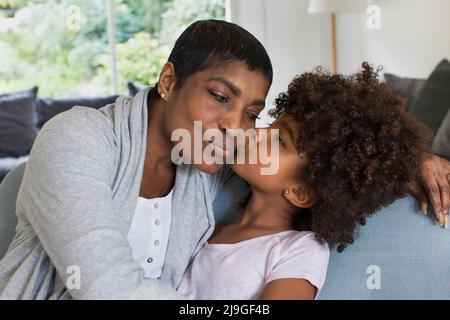 Glückliche Großmutter und Enkelin sitzen auf dem Sofa Stockfoto