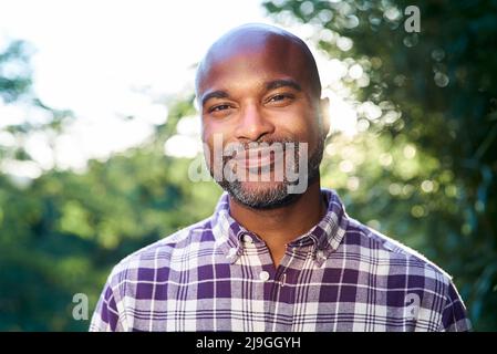 Nahaufnahme eines lächelnden Mannes, der im Garten steht Stockfoto