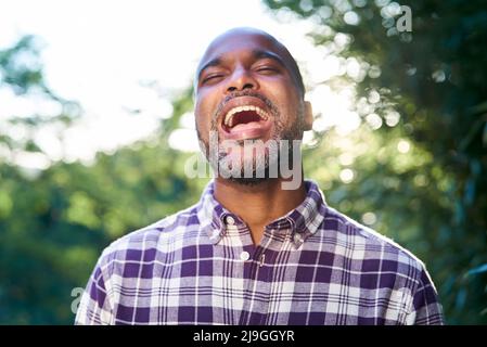 Nahaufnahme eines lachenden Mannes, der im Garten steht Stockfoto