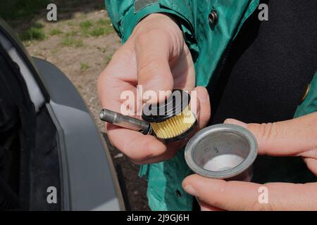 Nahaufnahme der Hände eines Mechanikers, der Autowartung und -Reparatur macht. Austausch des Gasfilters. Car Service-Konzept. Stockfoto