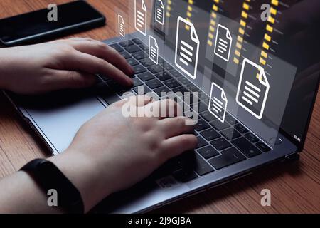 Frau verwenden Laptop mit virtueller holographischer Schnittstelle von Dokumenten. Document Management System (DMS)-Konzept. Prozessautomatisierung für effizientes Management. Stockfoto