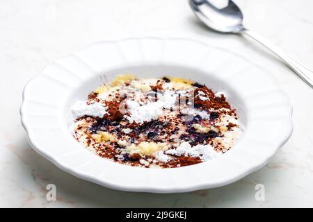 Grießbrei mit Kakao, Zucker und geschmolzener Butter Stockfoto