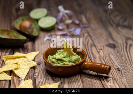 Avocado Dip mit Knoblauch, Chili, Pfeffer und Limettensaft mit Mais Nachos gewürzt Stockfoto