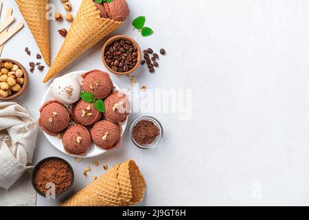 Kugeln aus Schokolade und Speiseeis auf grauem Hintergrund. Stockfoto