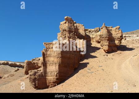 Sandig-lehmig Relief rote Felsen der Charyn-Schlucht vor dem Hintergrund eines klaren Himmels im Sommer Stockfoto