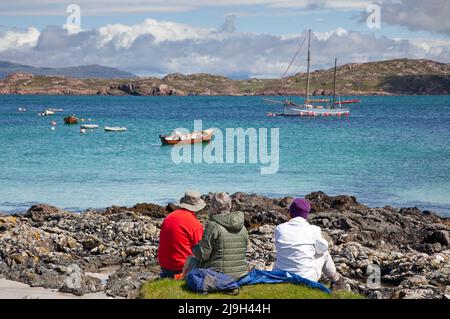 Isle of Iona, Innere Hebriden, Schottland, Großbritannien. 23. Mai 2022. Sonniger Nachmittag nach dem morgendlichen Nieselregen, die Temperatur steigt am Nachmittag auf 18 Grad, leichte Beeze hält die Mücken in Schach. Im Bild: Familie havng ein angenehmes Picknick mit einem schönen Blick über Sound of Iona. Quelle: Arch White/Alamy Live News. Stockfoto