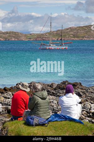 Isle of Iona, Innere Hebriden, Schottland, Großbritannien. 23. Mai 2022. Sonniger Nachmittag nach dem morgendlichen Nieselregen, die Temperatur steigt am Nachmittag auf 18 Grad, leichte Beeze hält die Mücken in Schach. Im Bild: Familie havng ein angenehmes Picknick mit einem schönen Blick über Sound of Iona. Quelle: Arch White/Alamy Live News. Stockfoto