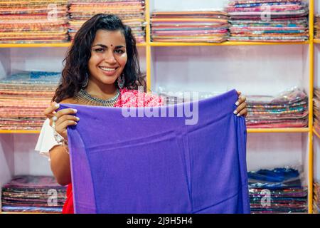 Geschäftsfrau in roten traditionellen Sari und Schmuck Kleidung Shop Besitzer Cashmere Yak Wolle Schals.Verkäuferin in goa indien arambol Verkauf shop.designer Stockfoto