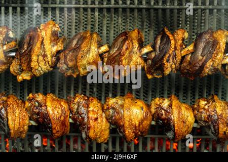 Schweinehähne schweine haxen stelzen Rösten auf dem Grill in München . Stockfoto