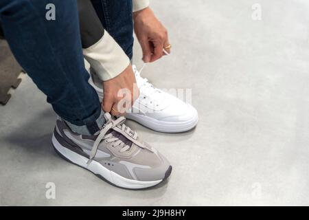 Ein Mädchen probiert in einem Sportartikelgeschäft neue Sneakers an Stockfoto