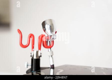 Nahaufnahme einer Spritzpistole auf unscharfem Hintergrund. Gerät für Konditoren Stockfoto