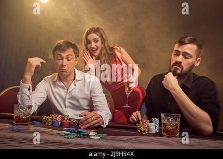 Eine Gruppe junger wohlhabender Freunde spielt Poker in einem Casino. Stockfoto