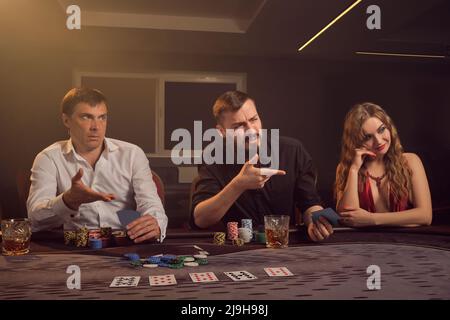 Eine Gruppe junger wohlhabender Freunde spielt Poker in einem Casino. Stockfoto