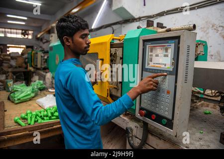 Neu-Delhi, Indien. 23.. Mai 2022. Ein Arbeiter betreibt eine automatische Spritzgießmaschine in einer Fabrik der Kunststoffhersteller in Neu-Delhi. Kredit: SOPA Images Limited/Alamy Live Nachrichten Stockfoto