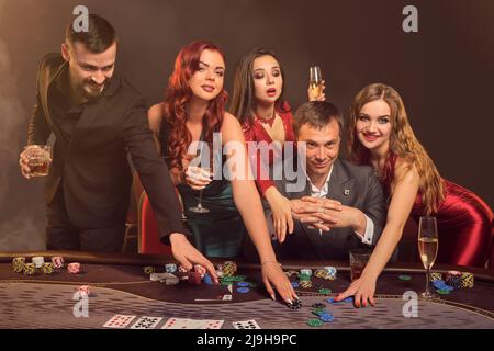 Eine Gruppe junger wohlhabender Freunde spielt Poker in einem Casino. Stockfoto