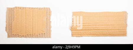 Zwei Stücke brauner Wellpappe auf weißem Hintergrund. Leere zerrissene Papier-Notizkarten aus Kraftkarton mit Platz für Text. Draufsicht Stockfoto