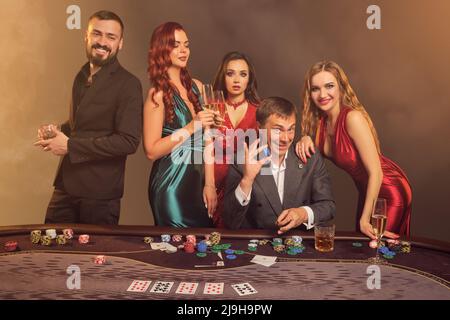 Eine Gruppe junger wohlhabender Freunde spielt Poker in einem Casino. Stockfoto