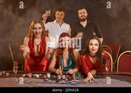 Eine Gruppe junger wohlhabender Freunde spielt Poker in einem Casino. Stockfoto