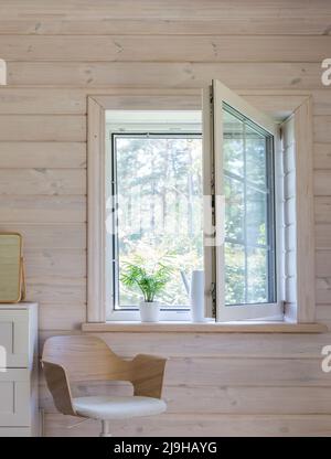 Weißes Fenster mit Mosuito-Netz in einem rustikalen Holzhaus Stockfoto