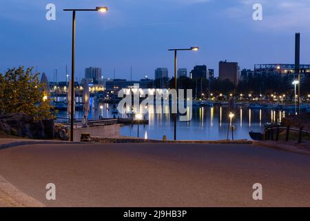 Helsinki / Finnland - 22. MAI 2022: Blick auf eine Uferpromenade mit einem ruhigen Meer und einer schlafenden Stadt im Hintergrund. Stockfoto