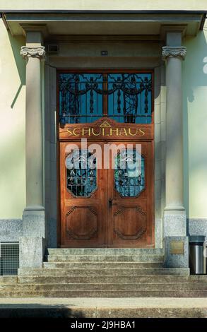 Wetzikon, Schweiz - 14. Mai 2022: Die Tür eines alten Schulhauses in Wetzikon, einer kleinen Stadt im Kanton Zürich Stockfoto