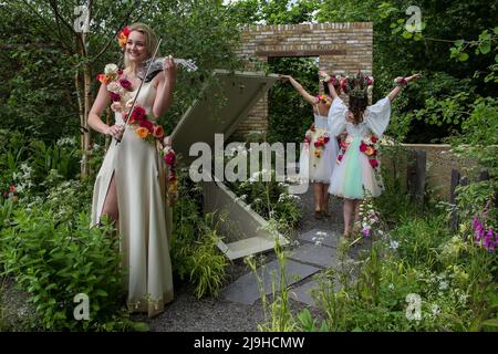 London, Großbritannien. 23.. Mai 2022. Die Geigerin Sally Potterton (vorne) mit Kate Garvie (L) und ihrer Tochter Ruby Garvie (R) posiert auf dem von Paul Hervey-Brookes entworfenen Brewin Dophin Garden auf der Chelsea Flower Show 2022 am Presseingunsttag. Kredit: SOPA Images Limited/Alamy Live Nachrichten Stockfoto