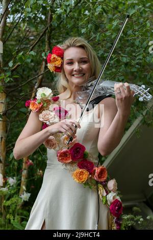 London, Großbritannien. 23.. Mai 2022. Die Geigerin Sally Potterton spielt auf dem von Paul Hervey-Brookes entworfenen Brewin Dophin Garden auf der Chelsea Flower Show 2022 am Presseingunstag eine Geige. Kredit: SOPA Images Limited/Alamy Live Nachrichten Stockfoto