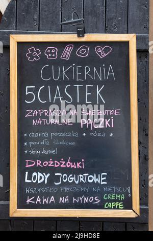 WARSCHAU, POLEN - 17. MAI 2022: Café Tafel Menü auf hölzernen Fensterläden in der Neustadt Stockfoto