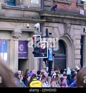 Manchester, Großbritannien, 23.. Mai 2022. Ein junger Mann findet einen hohen Aussichtspunkt, um die Parade zu beobachten. Der Manchester City Football Club veranstaltet eine Siegesparade, um den Titelgewinn des Clubs in der Premier League zu feiern, nachdem er am 22.. Mai im Etihad Stadium gegen Aston Villa gewonnen hatte. Die Parade der offenen Busse führte durch das Zentrum von Manchester, England, Großbritannien. Der Club sagte: „Der Club wird seinen Sieg mit Fans mit einer Open-Top-Busparade im Stadtzentrum von Manchester am Montag, dem 23.. Mai feiern, die mit einer Bühnenshow im Deansgate (Beetham Tower) endet.“ Quelle: Terry Waller/Alamy Live News Stockfoto