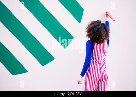 Frau mit Bleistift an der Wand Stockfoto